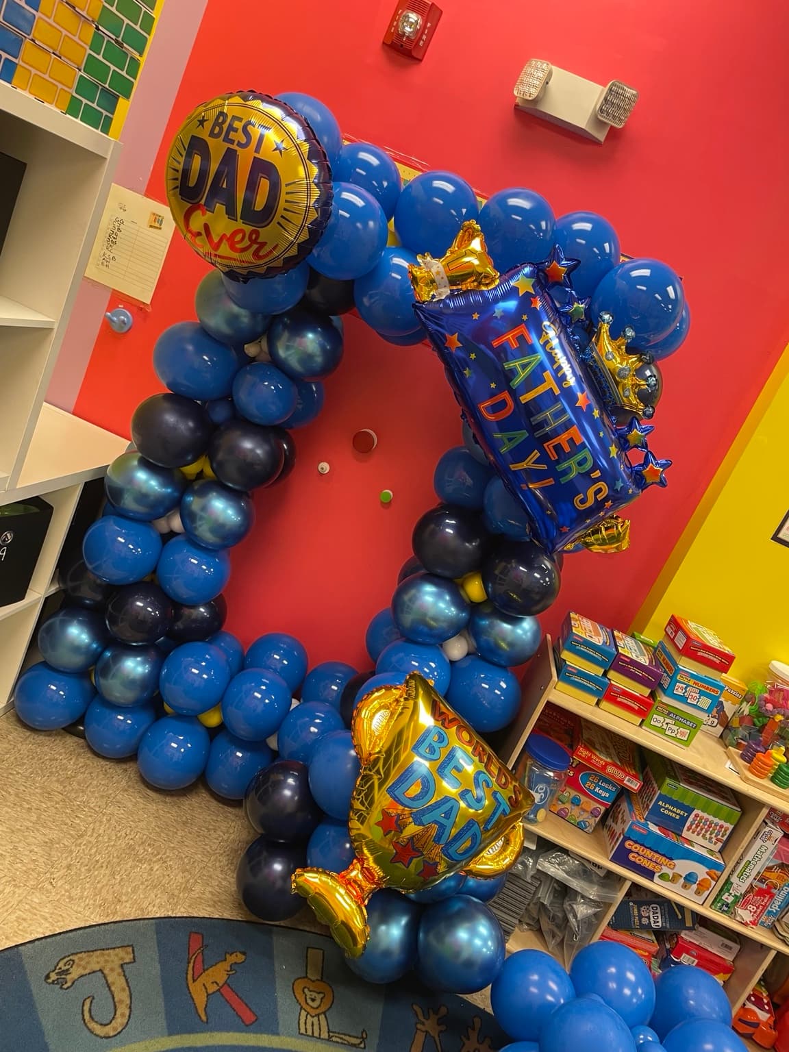 A 'World's Best Dad' Father's Day balloon arch decorating the classroom