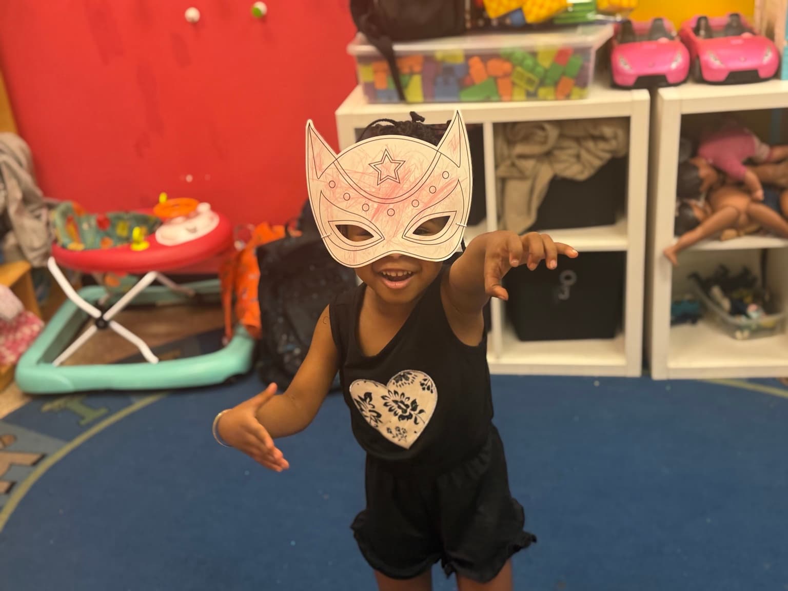 A child mid-motion wearing a handmade paper mask